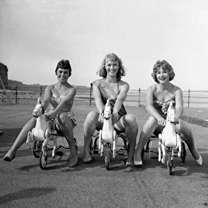 Beauty contest winners at Shanklin, UK. seen here riding childrens toy tri-cycles