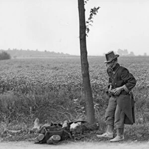 A Belgian soldier, wounded in the leg, falls by the roadside during the retreat
