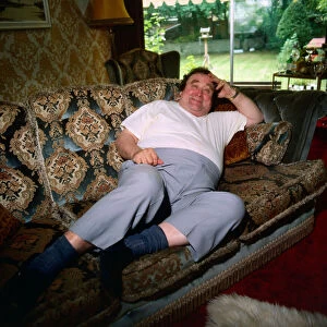 Bernard Manning at home lying on couch November 1989
