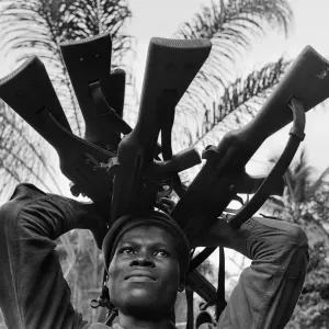 A Biafran soldier seen here holding a selection of guns during the Biafran conflict A Biafran soldier seen here holding a selection of guns during the Biafran conflict