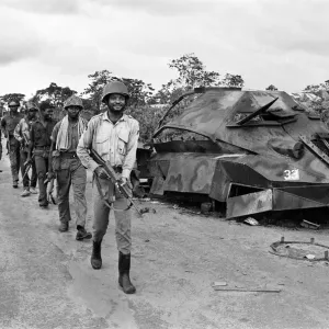 Biafran soldiers seen here marching past a destroyed Nigerian army armoured personnel Biafran soldiers seen here marching past a destroyed Nigerian army armoured personnel