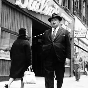 Billy Butlin walking past one of his Butlins shop on the high street. Dbase Billy Butlin walking past one of his Butlins shop on the high street. Dbase