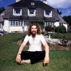 Billy Connolly 1988 Drymen sitting cross legged in front of house