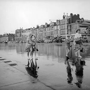 Blackpool after the storm. A couple of young holiday makers make their way off the beach