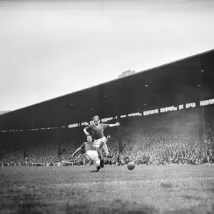 Bobby Charlton leaps to elude a defender during the match between Manchester United