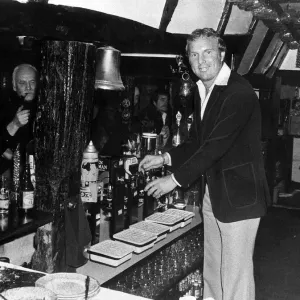 Bobby Moore ex futbolista sirviendo bebida detrás del bar The Three Horseshoes. Bobby Moore ex futbolista sirviendo bebida detrás del bar The Three Horseshoes.