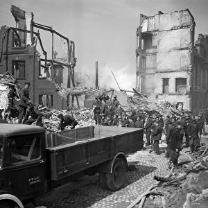 Bomb damage at Norwich during World War Two. Rescue workers at a bombed site after