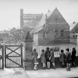 Dommages causés par des bombes à Saltburn, enfants regardant un bâtiment bombardé depuis une clôture en métal. Dommages causés par des bombes à Saltburn, enfants regardant un bâtiment bombardé depuis une clôture en métal.
