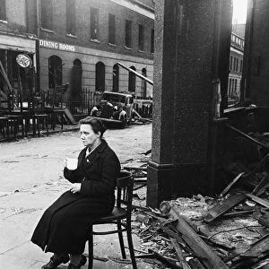Bomb damaged near Waterloo Station. A lady sits in solitary state drinking tea