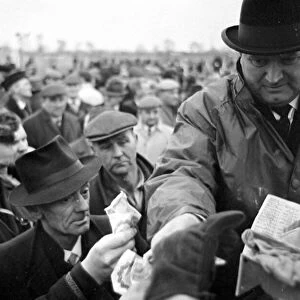 Bookmaker taking bets from crowds of punters before the race at Leopardstown in Ireland