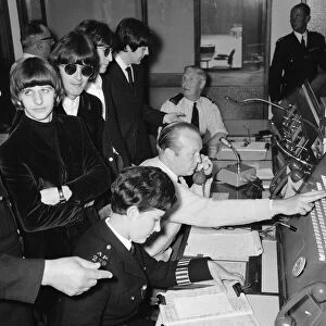 A bored looking Ringo Starr listens as the Beatles are shown around the new police