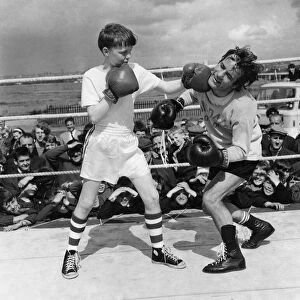 Boxer: Walter Mcgowan seen here in the ring during a training bout with a young admirer
