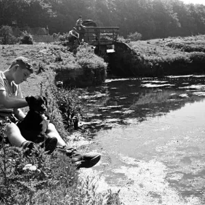 A boy sits with his pet dog next to the River Chess in Chenies, Buckinghamshire A boy sits with his pet dog next to the River Chess in Chenies, Buckinghamshire