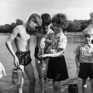 Boys and girls compare their catches after fishing for minnows in Kensington Gardens