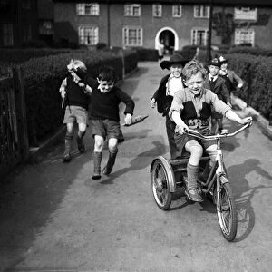 Boys playing on a council estate as one of their mothers looks on, London. 1955
