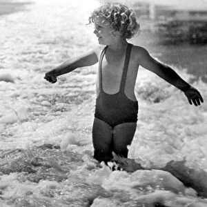 Brave young girl goes for a paddle in the sea while on holiday Circa 1945