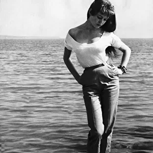 Brigitte Bardot French actress standing on rocks on sea shoreline, Cannes Film Festival