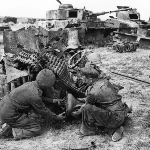 British army engineers remove the bearing from a wrecked vehicle in a dump which has