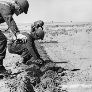 Print of British Army soldiers laying telephone cables in a desert trench Print of British Army soldiers laying telephone cables in a desert trench