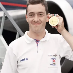 British cyclist Chris Boardman poses on arrival at Heathrow Airport as he returns home