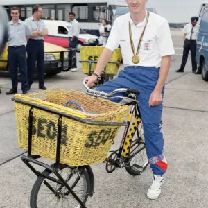 British cyclist Chris Boardman poses on arrival at Heathrow Airport as he returns home