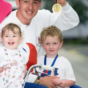 Le cycliste britannique Chris Boardman se pose avec sa famille à l'arrivée de l'aéroport de Manchester comme.