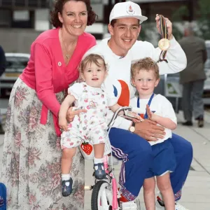 British cyclist Chris Boardman poses with his family on arrival at Manchester airport as