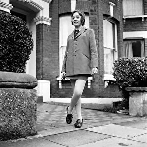 British family feature: Young teenage girl wearing school uniform walking down the street