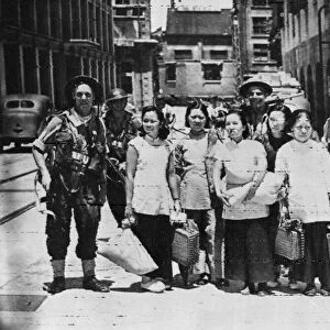 British Marines escort Chinese women from an occupied area in Hong Kong. 30th August 1945