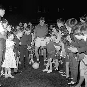 British rocker Tommy Steele playing football with children of the Tachbrook Estate in