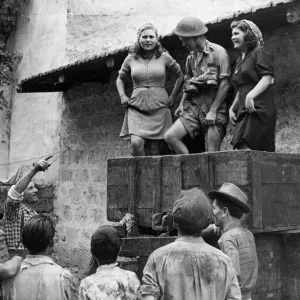 A British soldier helping the local villagers with the winepress after the Allied army A British soldier helping the local villagers with the winepress after the Allied army