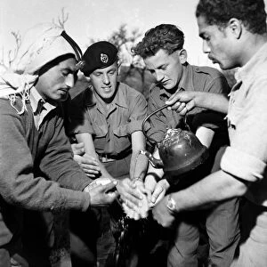 British soldiers and local Arab men enjoy a feast in Jordan. March 1952 C1287