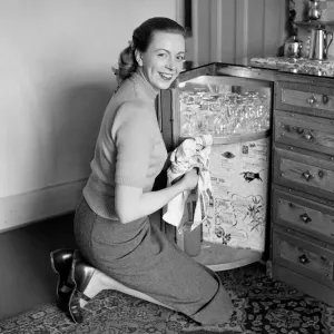 A busy housewife polishing the furniture at home Circa 1954 A busy housewife polishing the furniture at home Circa 1954