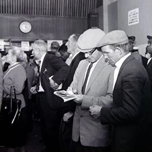 A busy scene inside a betting shop with punters queuing to make bets minutes before