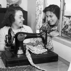 Busy at her sewing machine is Mrs. Beaty Evans, her next door neighbour, Mrs
