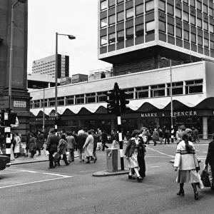 Busy street scene showing pedestrians crossing the road at the corner of Cross Street
