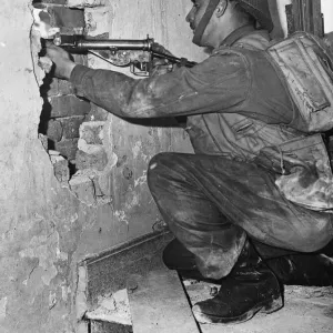 Canadian soldier Corporal Andy Mouflier from Winnipeg, fires a peephole in the wall of a