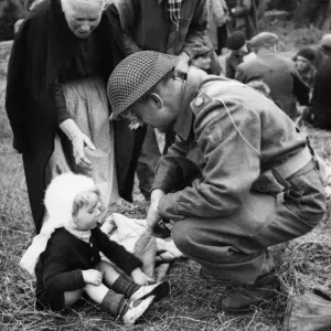 Canadian soldiers tend to French Refugees in Normandy shortly after the successful Canadian soldiers tend to French Refugees in Normandy shortly after the successful