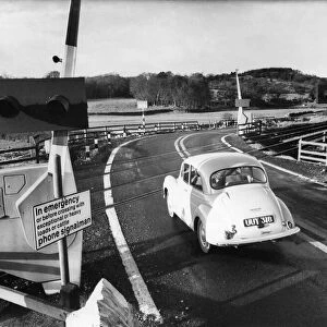 A car crosses over a continental style level crossing. January 1968