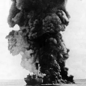 A cargo steamer hit by a u-boat torpedo seen here burning and sinking by the bow A cargo steamer hit by a u-boat torpedo seen here burning and sinking by the bow