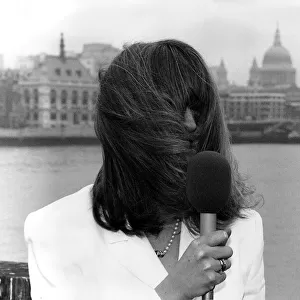 Caron Keating TV Presenter holding microphone hair blowing over her face