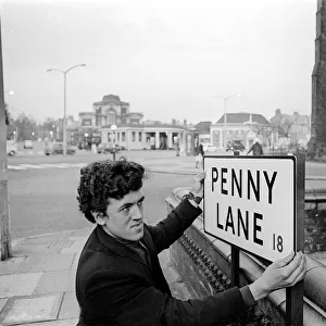 Bill Carrington holds Penny Lane Street Sign in Liverpool made famous by The Beatles