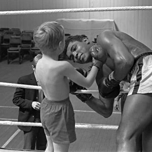 Cassius Clay with 6 year old Patrick Power in the ring during his training for