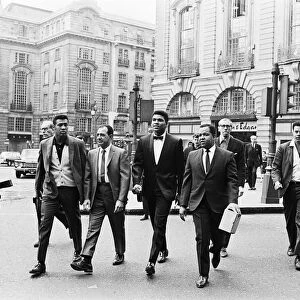 Cassius Clay (centre) and entourage in Piccadilly Circus on route to his press conference
