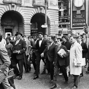 Cassius Clay et son entourage se promenant dans Regent Street en route pour sa conférence de presse. Cassius Clay et son entourage se promenant dans Regent Street en route pour sa conférence de presse.