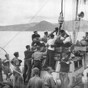 A casualty from a minesweeper being lifted on board the British cruiser Orion from a