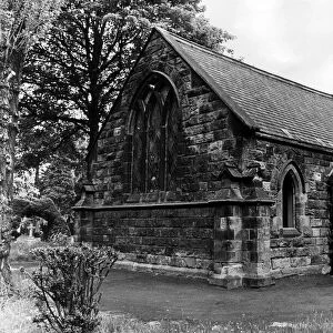 The Chapel among the trees at Eston cemetery, one of the panes in the leaded windows is