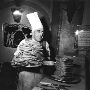 A chef with two huge piles of toast. April 1947