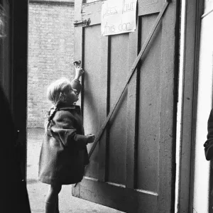 Child closing the door to the classroom following morning break at Roxeth Primary School