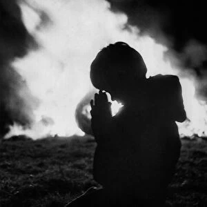 A child prays against the flames of the Bonfire at Stewkley. December 1970 P000327